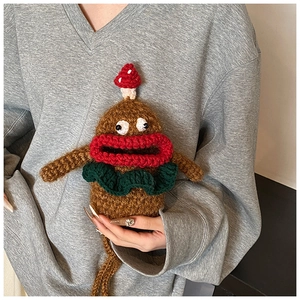 Detailed macro view of handmade crochet doll bag with large red lips and mushroom detail