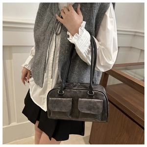Dettaglio della borsa bowling vintage grigio scuro con doppie tasche frontali e manici in pelle