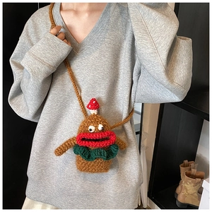 Detail of a handmade brown curly wool bag with large red lips and mushroom decor