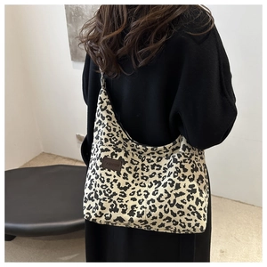 Detail of leopard print corduroy tote bag showing soft texture and leather fashion label