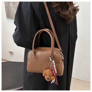Vintage dark brown Boston bag with teddy bear charm and embossed logo detail for women