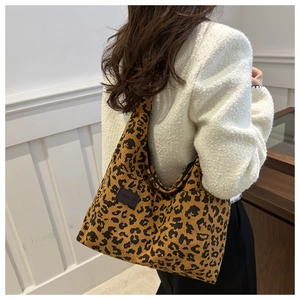 Close-up of leopard print corduroy tote bag featuring a leather fashion tag on the side