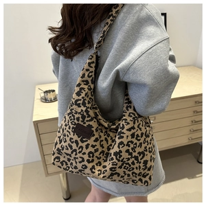 Detailed texture of leopard print corduroy tote bag with fashion label shown on model