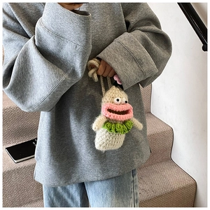 Handmade crochet cartoon shoulder bag with big eyes and pink lips worn by a model