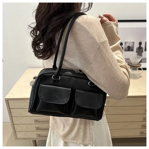 Dettaglio borsa tote in ecopelle nera con doppie tasche frontali e cerniere argento