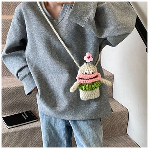 Close-up of handmade crochet monster crossbody bag with pink lips and knitted texture