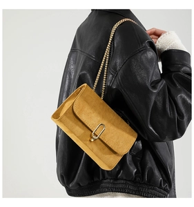 Detailed close-up of ginger yellow frosted crossbody bag with vintage gold metal lock buckle