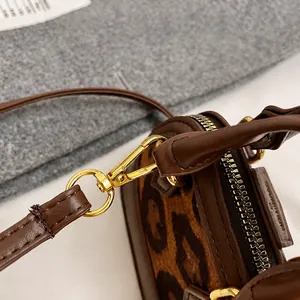 Detail of premium gold-tone hook on a leopard print canvas and brown leather handbag