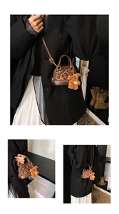 Detailed view of mini leopard print shell bag with detachable strap and plush bear charm