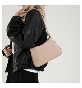 Chic beige leather shoulder bag styled with a leather jacket and knot strap detail