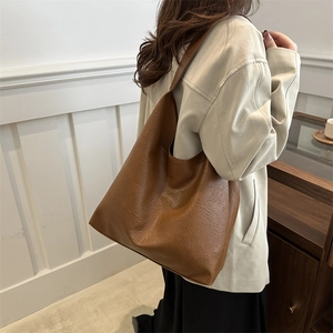 Retro brown oversized hobo tote bag with lychee texture shown on model's shoulder