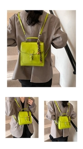 Detail of bright green vintage backpack with decorative strap and woven bell charm