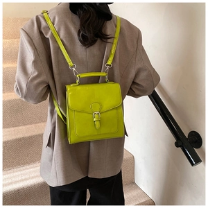 Fashionable neon green faux leather backpack shown with a blazer on a model's back