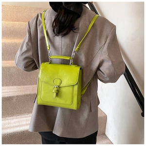 Detail of neon green oil wax leather backpack with square flap and metal buckle closure