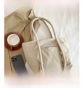 Detail view of large beige tote bag with a minimalist design and soft nylon texture