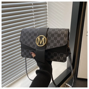 Detail of grey monogram leather bag with golden M logo buckle and thin strap
