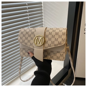 Detail of beige jacquard small square bag with letter M pattern and gold metal hardware