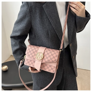 Model wearing pink shoulder bag with gold circle logo and letter pattern detail