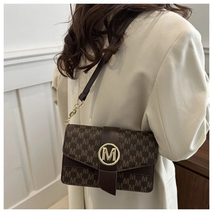 Detail of vintage brown monogram bag featuring gold M buckle and elegant leather strap