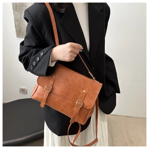Vue détaillée de la serviette en cuir marron avec gaufrage lucky LHCO et boucles en métal