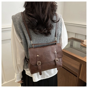 Vue détaillée du sac à dos vintage marron foncé avec cuir mat et boucles métalliques dorées