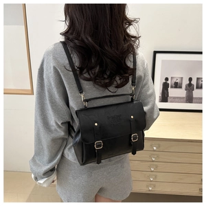 Détail du sac à dos vintage noir montrant des boucles dorées et le gaufrage LHCO Emu
