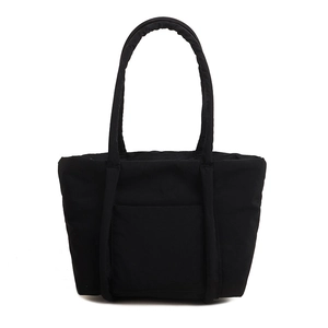 Minimalist black quilted tote bag with padded nylon texture and front pocket for women
