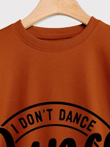 Detail of the ribbed crewneck and 'I DON'T DANCE' print on rust red sweatshirt
