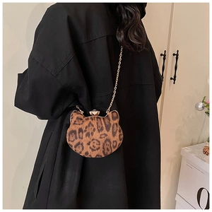 Cat-shaped leopard print chain bag with gold buckle styled on a black winter coat