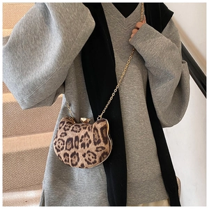 Detailed view of leopard print cat-shaped chain bag worn as a stylish crossbody accessory