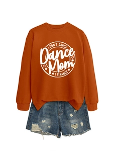 Flat lay of burnt orange crewneck sweatshirt with white graphic print and distressed denim shorts