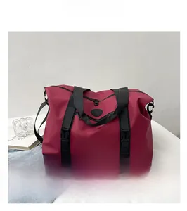 Detail view of large burgundy travel bag showing durable buckles and nylon texture
