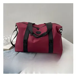 Close-up of a large red travel bag with black straps and a smartphone for size comparison