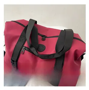 Detail of red travel duffel bag with reinforced black handles and external zip pockets