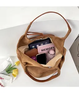 Top view of large brown suede tote bag interior showing spacious storage for tablet and books