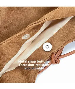 Macro view of silver magnetic snap closure on brown suede hobo bag with fabric lining