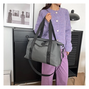 Close-up of a large grey travel bag featuring durable nylon fabric and plastic buckles