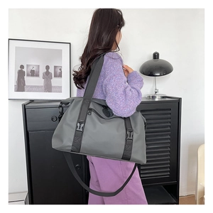 Close-up of waterproof fabric and reinforced buckle on grey large travel bag