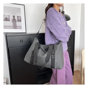 Detail of grey waterproof nylon travel bag with detachable strap and shoulder carry style