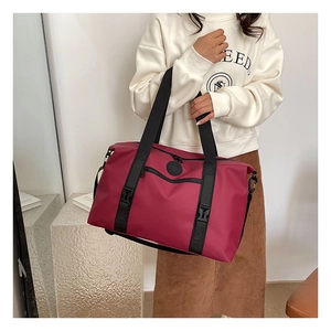 Detail of the large magenta travel bag with sturdy black straps and reinforced buckles