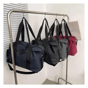 Detailed row of large waterproof travel bags in navy, black, grey and wine red nylon