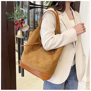 Detail of a large ginger faux suede tote bag with a minimalist bow and thin straps