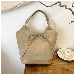 Detailed close-up of khaki tote bag with matte texture and decorative bow tie