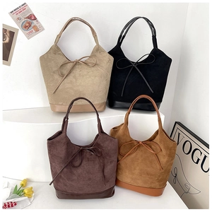 Detail view of four suede tote bags in beige, black, brown, and caramel with leather base