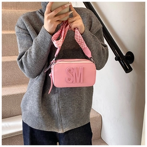 Pink crossbody bag with SM embossed detail and geometric patterned shoulder strap