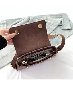 Interior detail of brown suede underarm bag showing zipper compartment and storage capacity