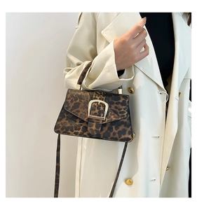 Detail of vintage leopard print crossbody bag featuring a golden square buckle and texture