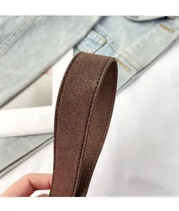 Detail of thickened brown suede shoulder strap with precise stitching on a baguette bag