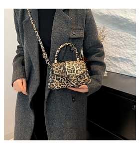 Close-up of vintage leopard print crossbody bag with golden buckle on wool coat