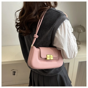 Detail of a pink leather shoulder bag with a gold geometric clasp and knotted strap